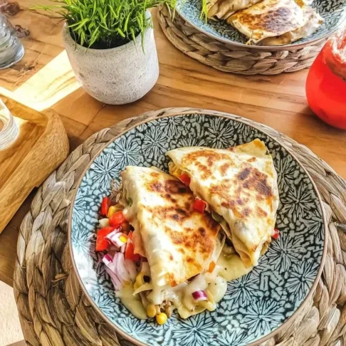 Ostquesadilla med majs och paprika på tallrik.